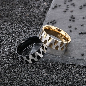 Macro detail of wave texture rings in silver, black, and gold finish on stone