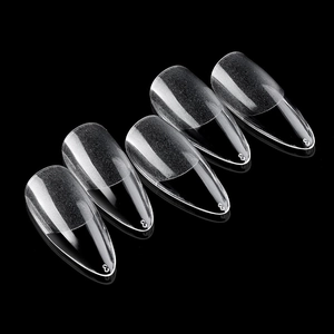 Set of clear almond stiletto fake nail tips with seamless matte finish on dark background