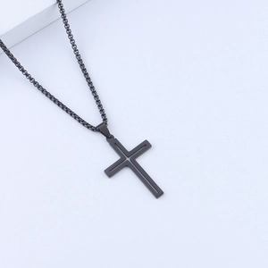 Detail of a minimalist black stainless steel cross pendant with a sleek box chain design