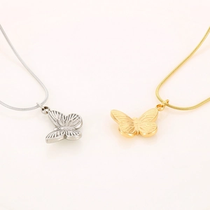 Macro detail of gold and silver butterfly pendants on minimalist titanium steel necklaces