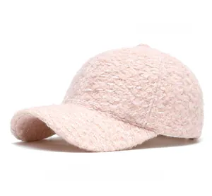 Detailed close-up of light pink tweed baseball cap with premium woven texture and curved brim