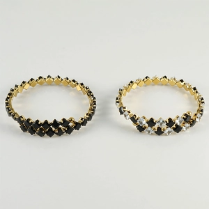 Macro detail of geometric cubic zirconia gold bracelets with black and white crystal settings
