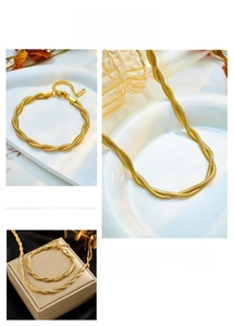 Dettaglio del set collana e bracciale a catena serpente intrecciata placcata oro