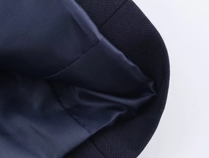 Detailed macro view of the navy blue blazer fabric showing smooth satin lining and stitching