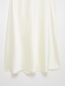 Détail de l'ourlet de la robe en satin blanc avec un drapé élégant et une texture soyeuse
