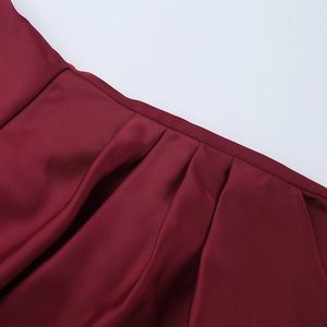 Detailed close-up of wine red satin evening dress featuring waist stitching and pleated texture