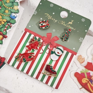 Détail d'un lot de 6 broches de Noël en émail avec bonhomme de neige sur carte cadeau décorée