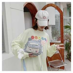 Light blue canvas crossbody bag with cute ear detail and white teddy bear keychain