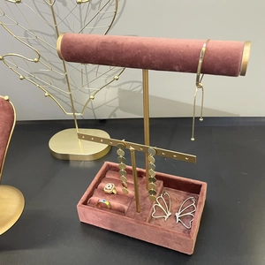Elegant dusty pink velvet jewelry display set with metal stand on a grey surface
