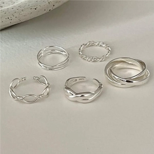 Flat lay of minimalist 925 sterling silver ring set on elegant ceramic background