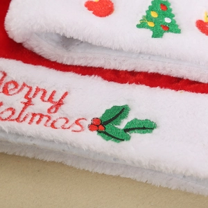 Macro detail of plush Christmas hat featuring festive embroidery and Merry Christmas text