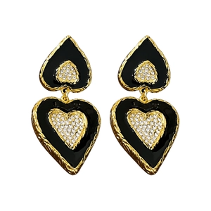 Vintage heart earrings with black enamel, gold metal edges and rhinestones on white background