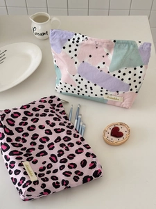 Detail of trendy leopard print and abstract pattern makeup bags with branded woven label