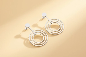 Macro view of geometric triple-layer concentric circle stud earrings in silver finish