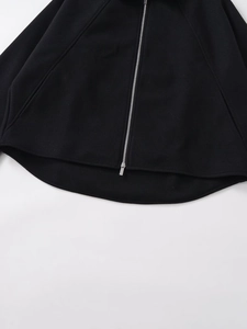 Detailed close-up of the smooth silver zipper and hem on a black wool blend hoodie