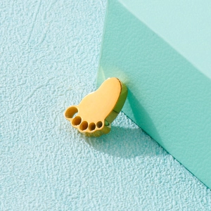 3D gold stainless steel footprint pendant accessory on a soft blue textured surface
