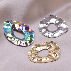 Macro shot of 18k gold, silver and iridescent hammered geometric jewelry pendants