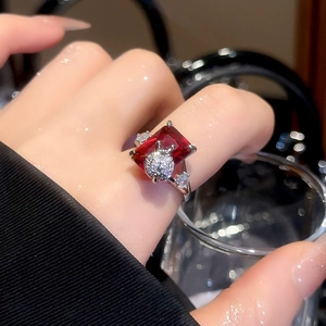 Detail of red rectangular ruby ring with diamond beetle decor on woman's finger