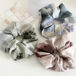 Gros plan de chouchous en tissu plissé aux motifs floraux vintage et aquarelle doux