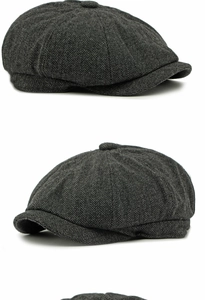 Detailed close-up of dark grey herringbone wool newsboy cap showing fabric texture