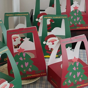 Close-up of red and green Christmas gift boxes with Santa and heart tree patterns