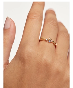 Close-up of a slim gold S925 silver ring featuring colorful inlaid stones on a finger