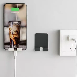 Wall-mounted phone charging holders in black and white minimalist plastic design