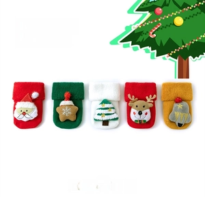 Detail of five styles of plush Christmas baby socks with festive 3D cartoon appliqués