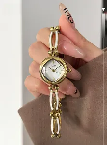 Close-up of women's gold quartz watch with mother of pearl dial on wrist