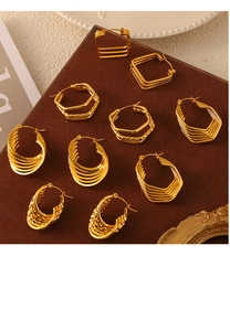 Macro shot of assorted gold titanium steel geometric hollow earrings on a vintage display