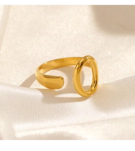Macro detail of gold plated oval ring on silk fabric with elegant warm lighting