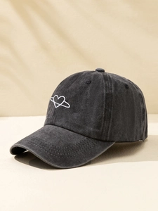 Close-up of heart planet embroidery on washed black cotton baseball cap fabric