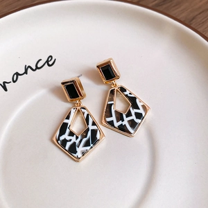 Gros plan de boucles d'oreilles géométriques avec motif zèbre et cadre doré