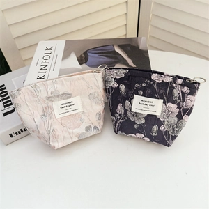 Close-up of vintage corduroy pouches in beige and navy blue with floral jacquard details