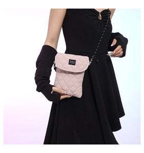 Detail view of pink quilted crossbody phone bag with black Fashion label on flap