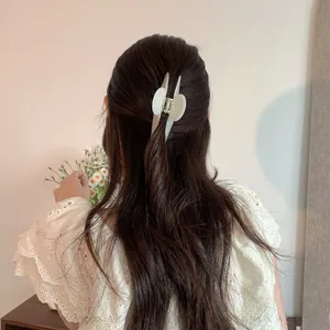 Detail of cream acetate hair claw clip on long hair with elegant butterfly shape design