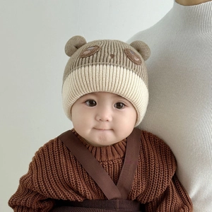 Detail of baby winter knit hat with 3D ears, cartoon embroidery and thick ribbed texture