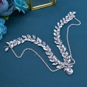 Elegant silver bridal headpiece with crystal leaf chain design on a blue background