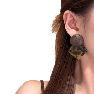 Boucles d'oreilles géométriques en bois et acétate portées par un mannequin