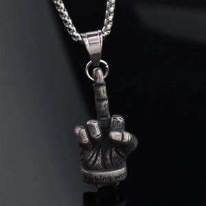 Macro shot of vintage silver middle finger gesture pendant on reflective black background