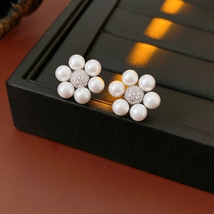 Macro detail of French vintage pearl flower earrings with sparkling zircon center