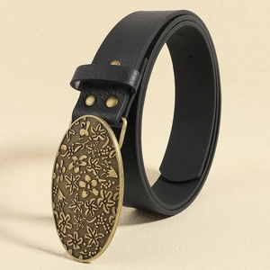 Detail of vintage black belt featuring ornate floral engraved antique brass buckle