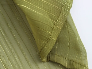 Macro detail of olive green chiffon fabric with delicate gold metallic stripes