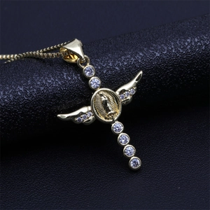 Macro detail of golden cross pendant with angel wings and Virgin Mary icon on black leather