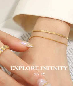 Close-up of double-layer golden snake chain bracelet and zircon ring set for women