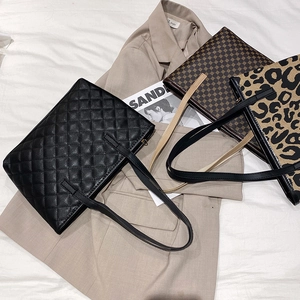 Chic women's tote bags in quilted black, geometric print, and leopard patterns on bed