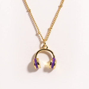 Detailed close-up of golden necklace featuring a purple enamel headphone shaped pendant
