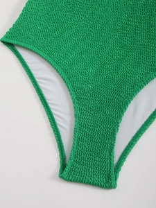 Vue détaillée du tissu de maillot de bain froncé vert avec texture élastique et doublure