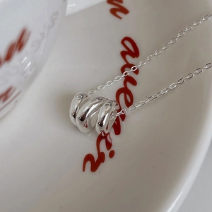 Macro shot of silver S925 sterling silver necklace with unique wavy curled pendant design