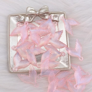 Luminous pink glitter acrylic mermaid tail pendants on white plush background